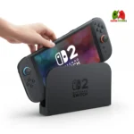 “Sleek Nintendo Switch 2 console resting in its dock, with magnetic Joy‑Con 2 controllers attached, displaying gameplay on a TV screen.”
